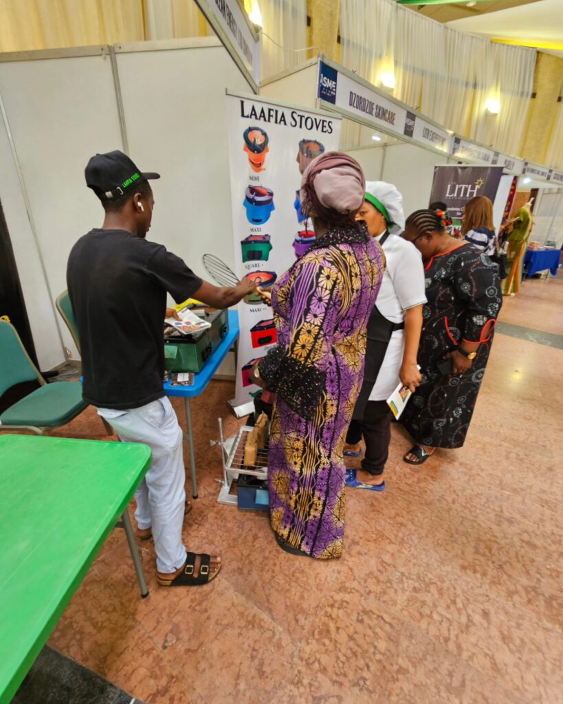 Methanogreen team demonstrating Laafia stoves to exhibition visitors in Abuja